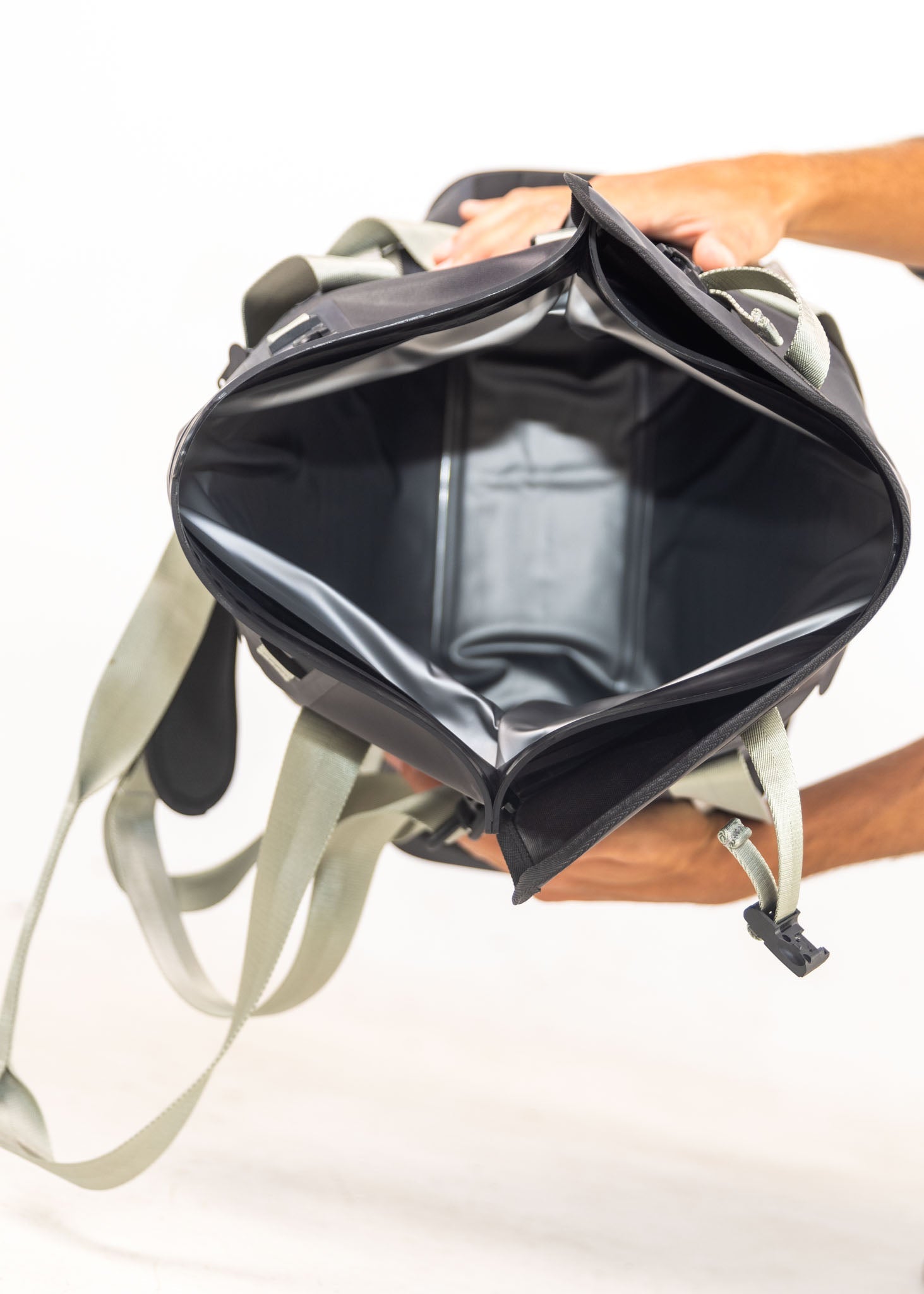 Person holding a black and gray backpack with a white background