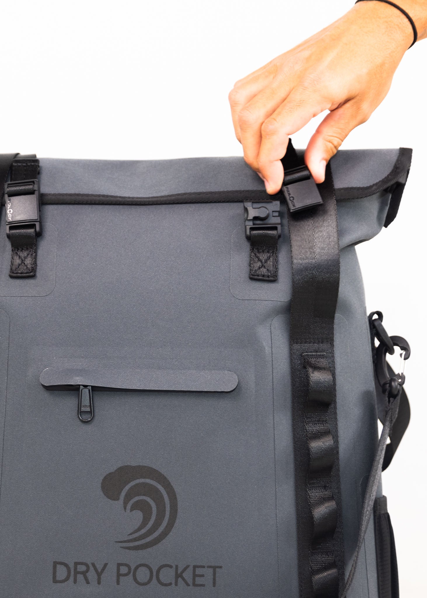 Gray waterproof bag with 'Dry Pocket' logo being held by a hand.