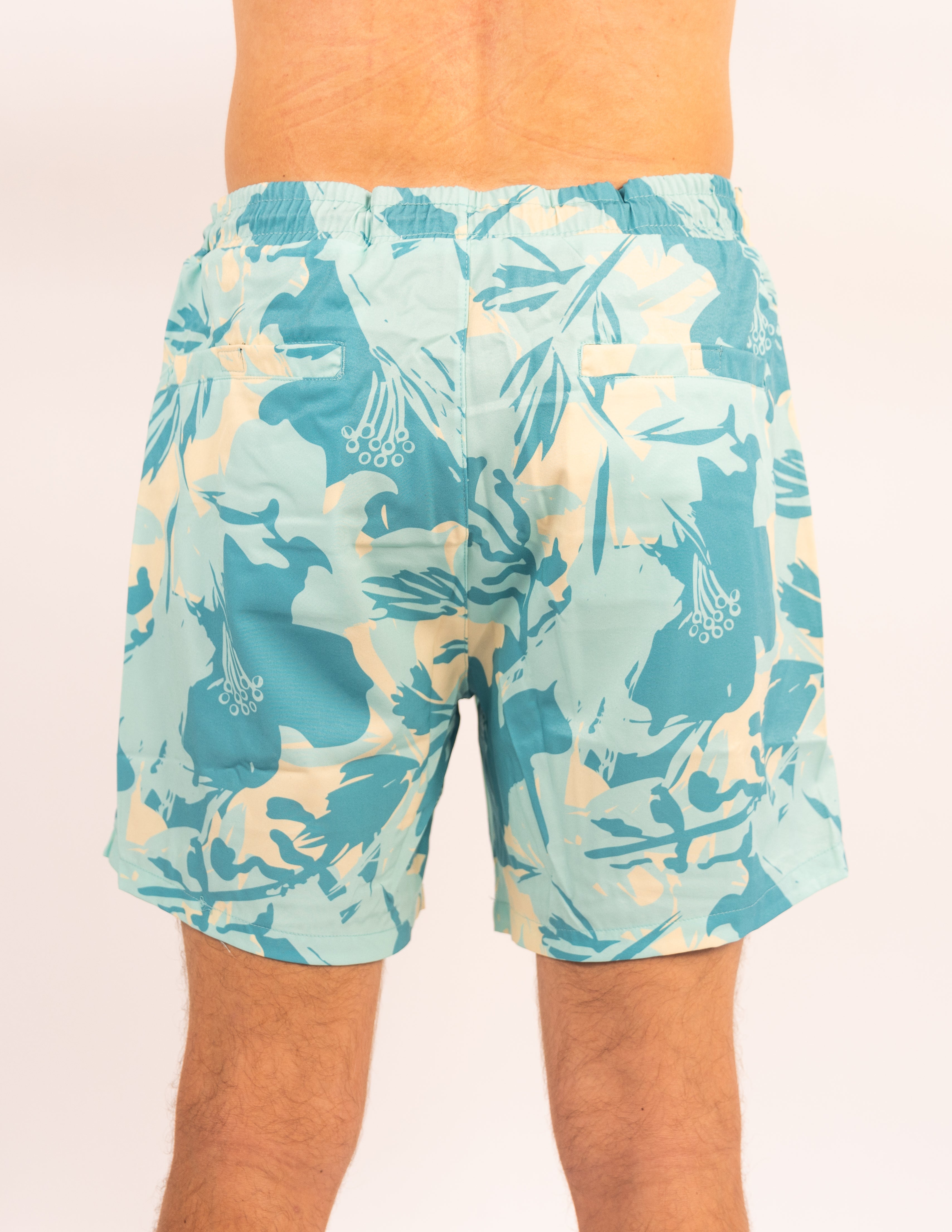Tropical patterned swim shorts on a plain background