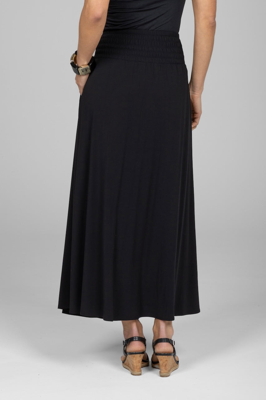 Person wearing a black skirt on a plain background
