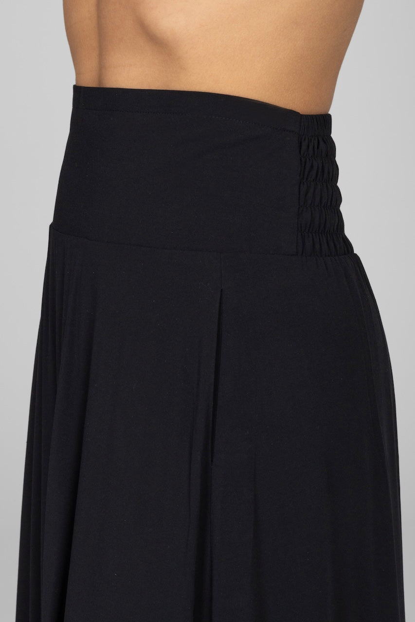 Black skirt worn by a person on a plain background