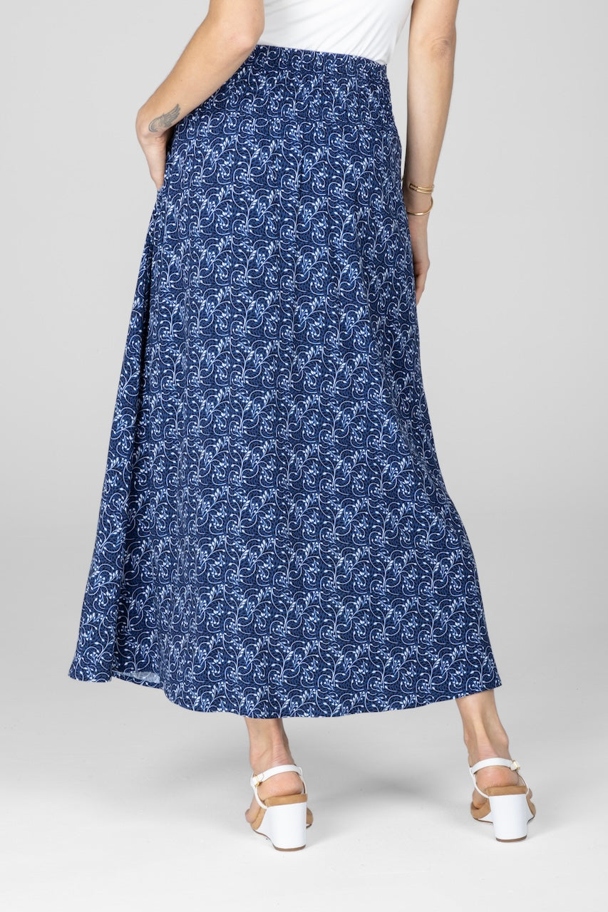 Person wearing a blue patterned skirt on a white background