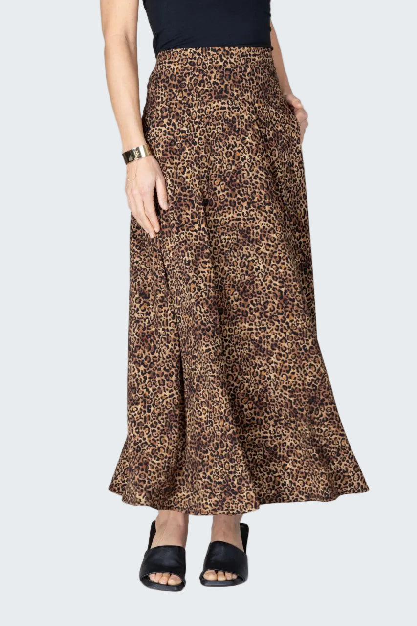 Person wearing a leopard print skirt on a beige background