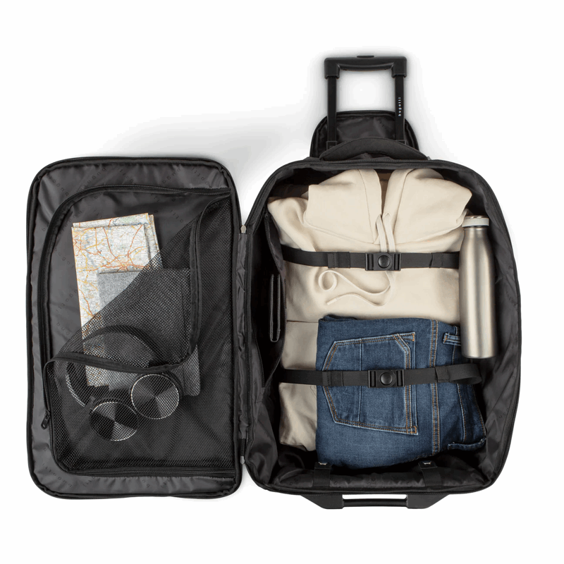 Open suitcase with clothes and a map on a white background