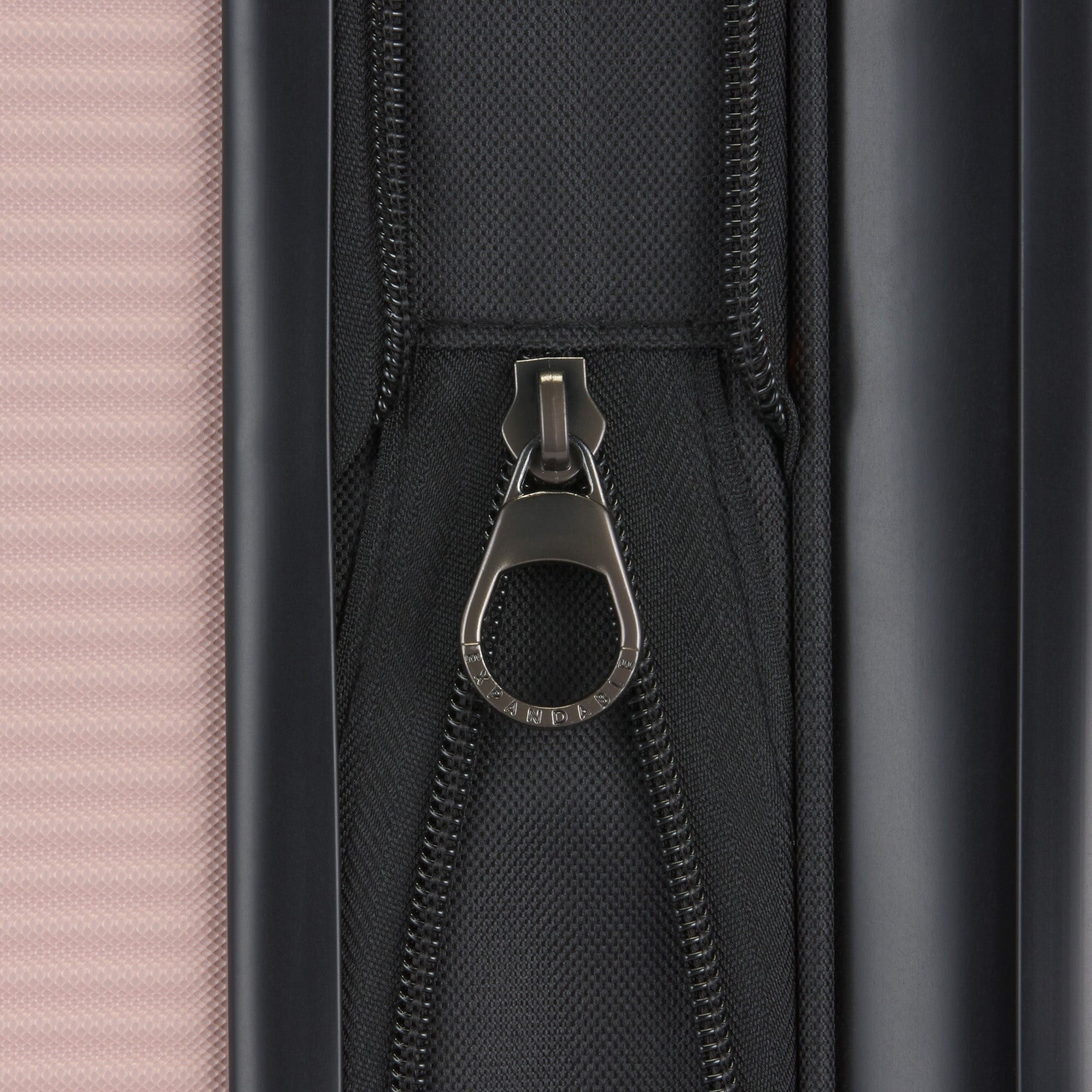 Close-up of a zipper on a suitcase with a pink and black design.