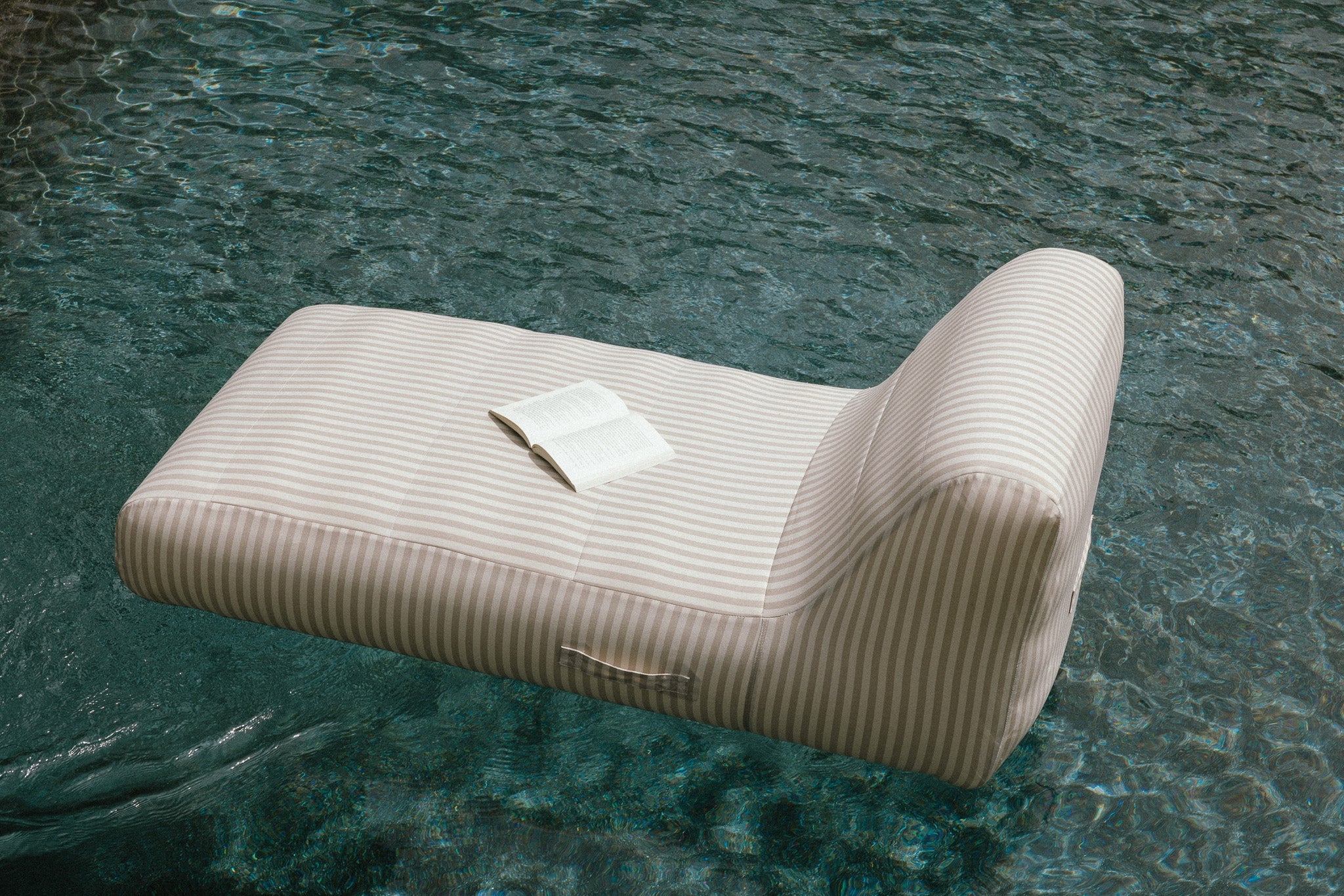 Modern lounge chair with a textured design floating on water