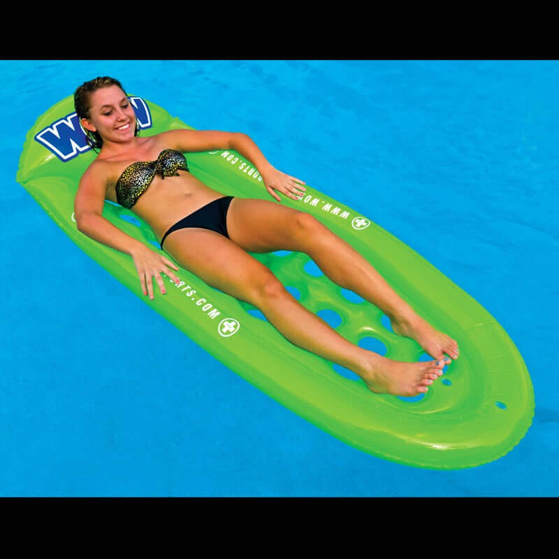 Woman lying on a green inflatable pool float with a blue background