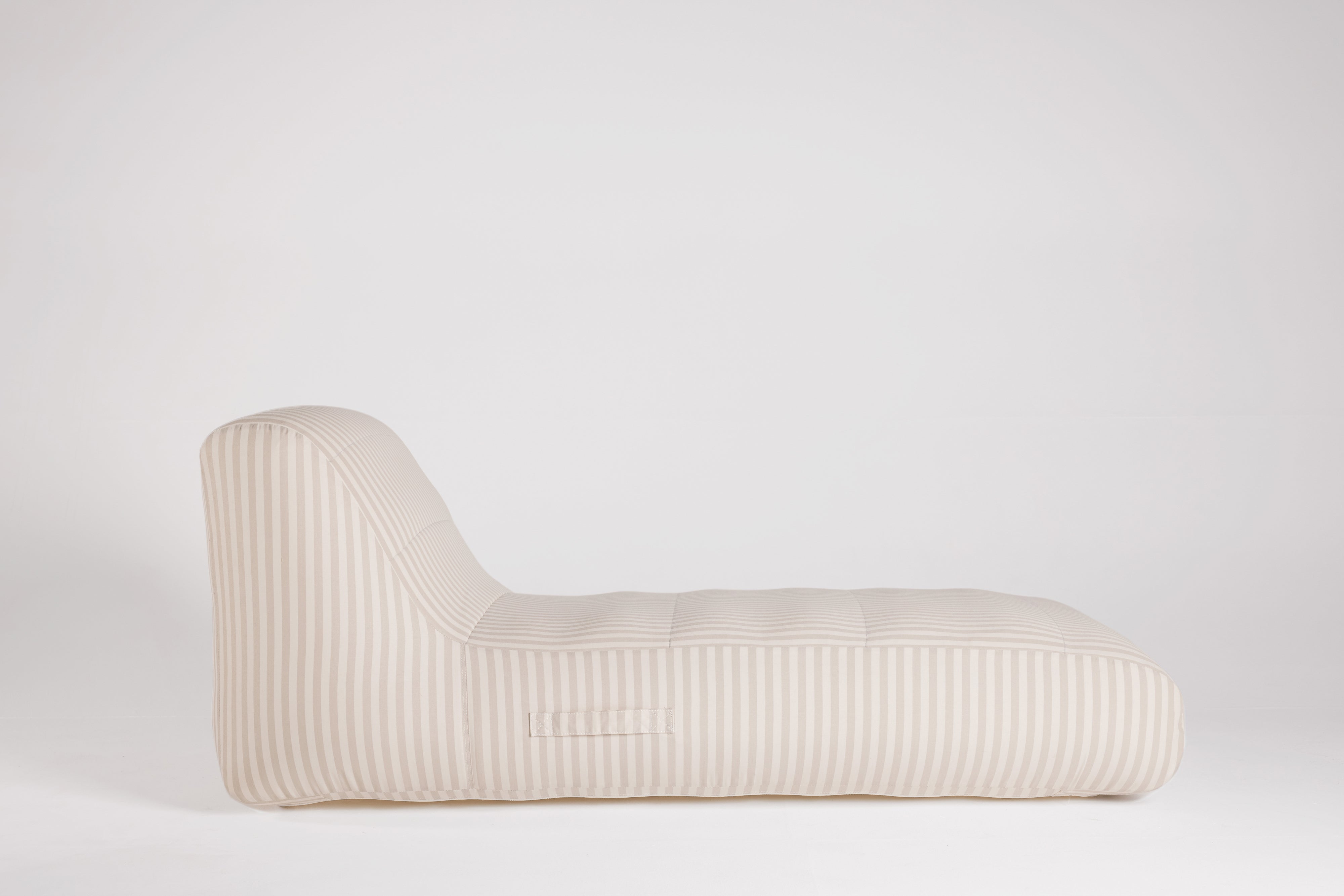 Beige ribbed lounge chair on a white background