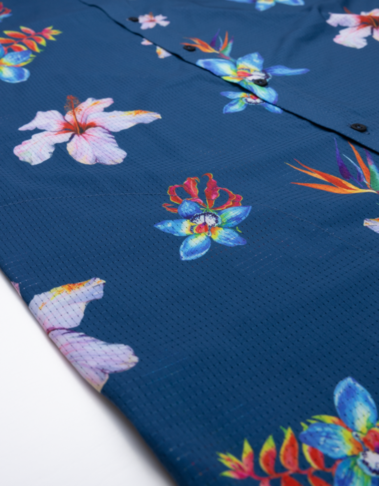 Close-up of a blue shirt with colorful floral patterns on a white background