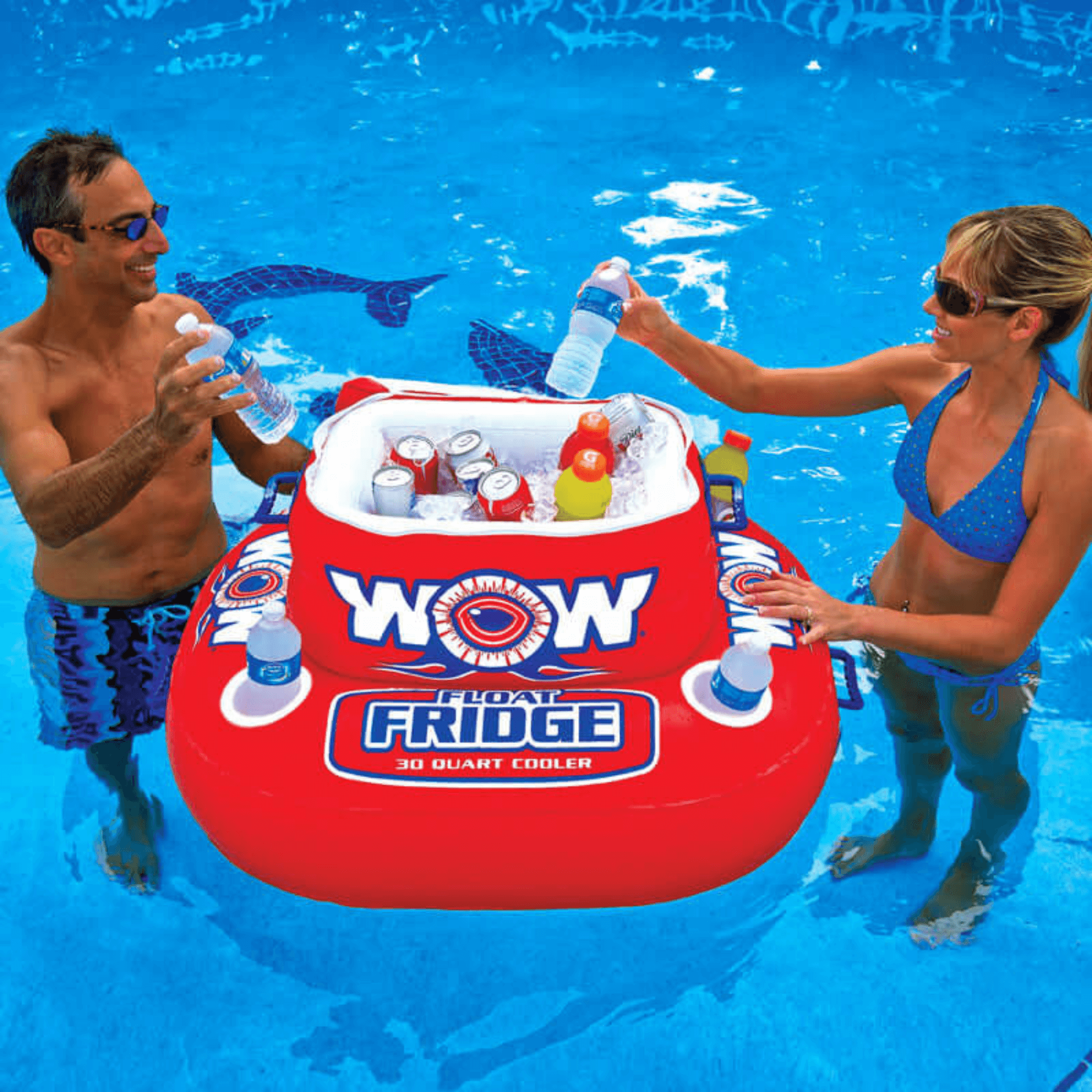 Two people interacting with an inflatable 'WOW' floating fridge in a pool.