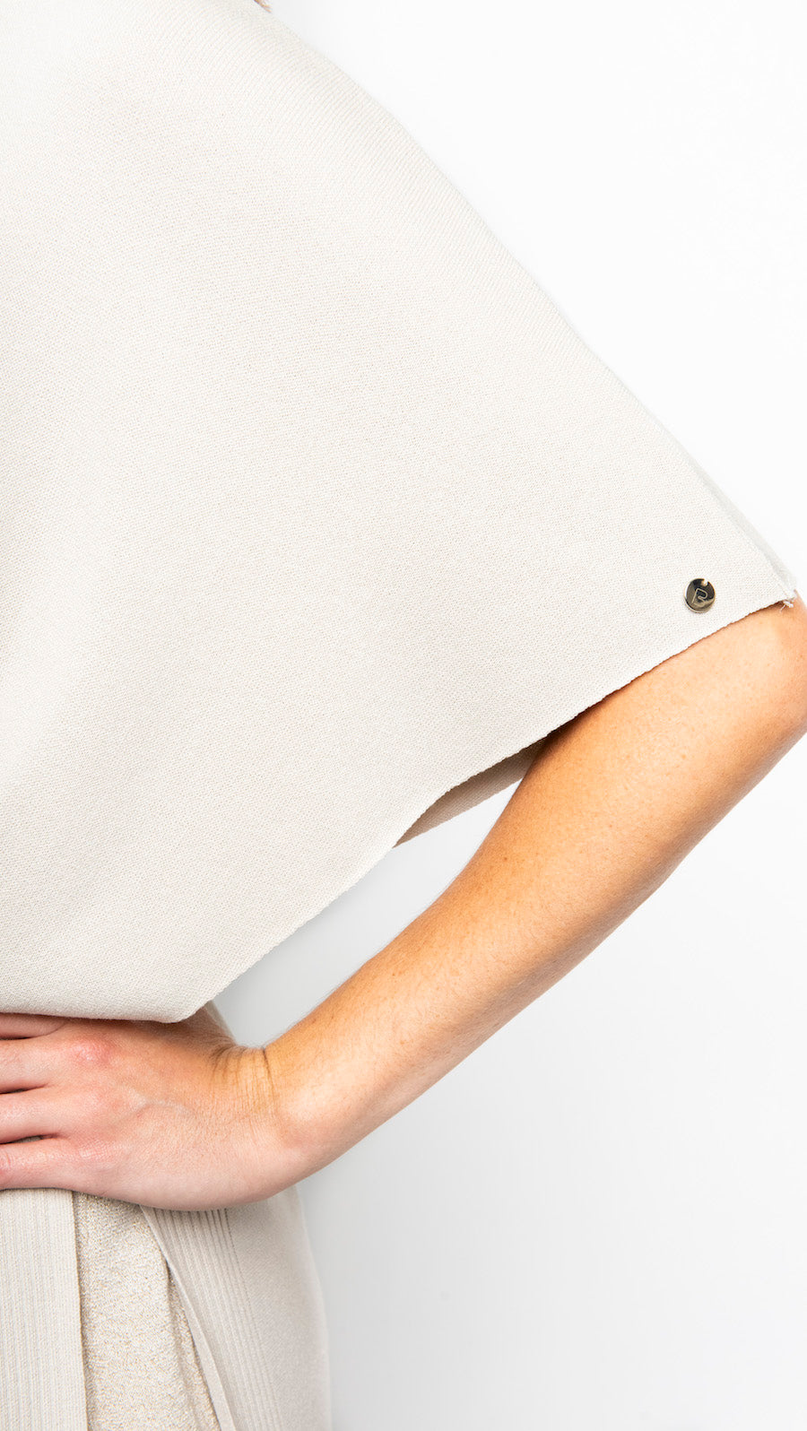 Close-up of a person wearing a beige shirt with a plain background