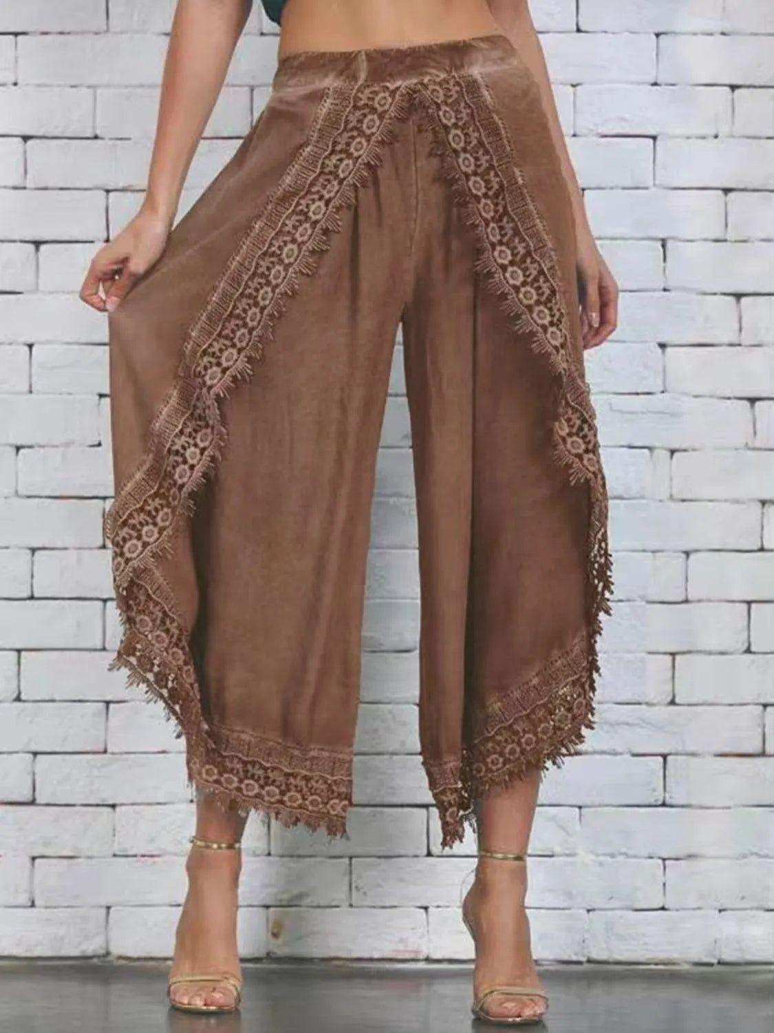 White wide leg pants with lace detailing at the hem, shown on a model wearing high heels.
