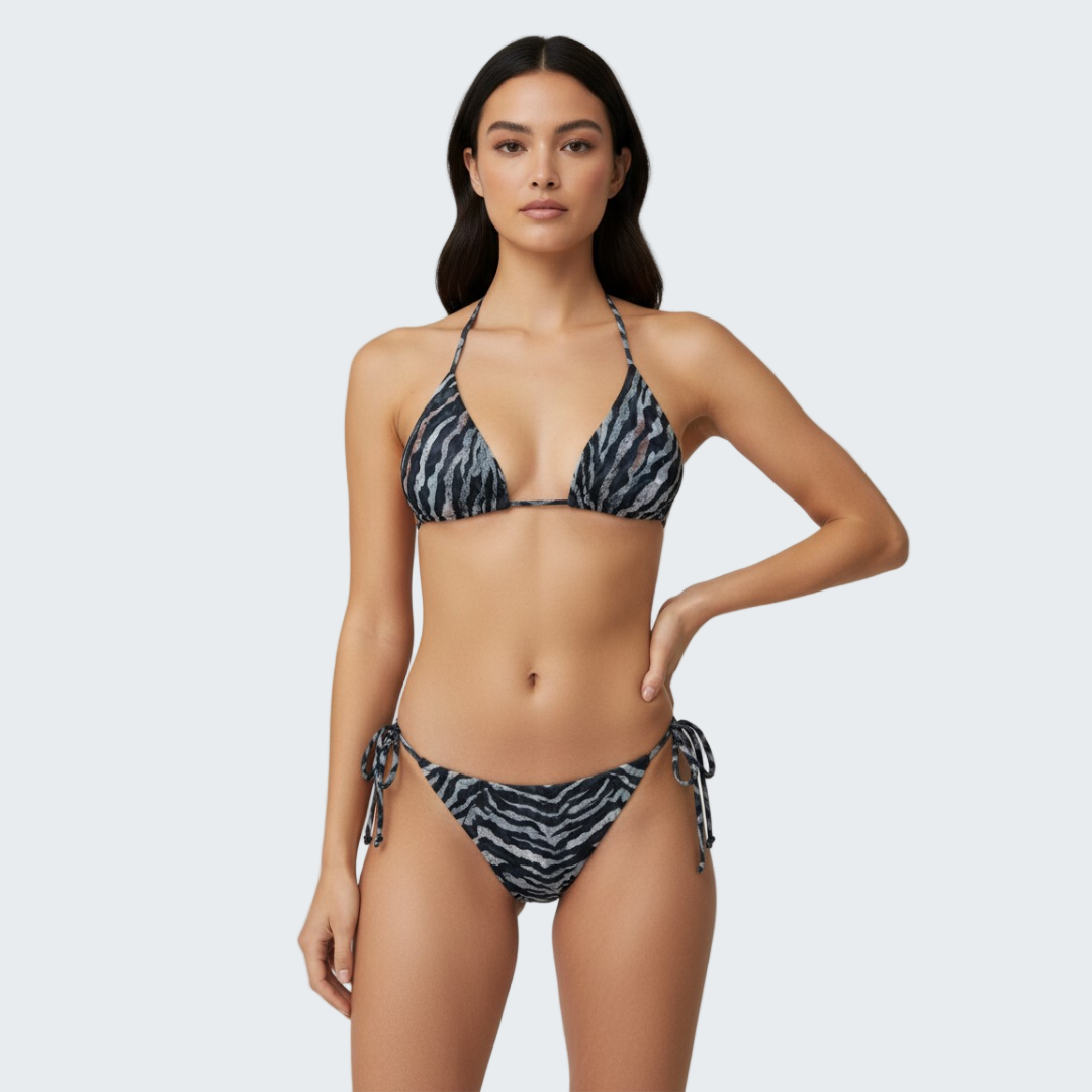 Woman wearing a black and white patterned bikini against a plain background