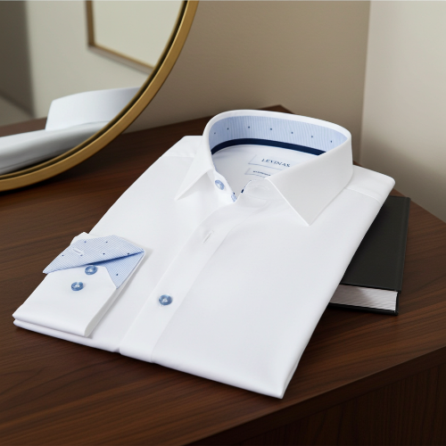 Folded white dress shirt with blue accents on a wooden surface