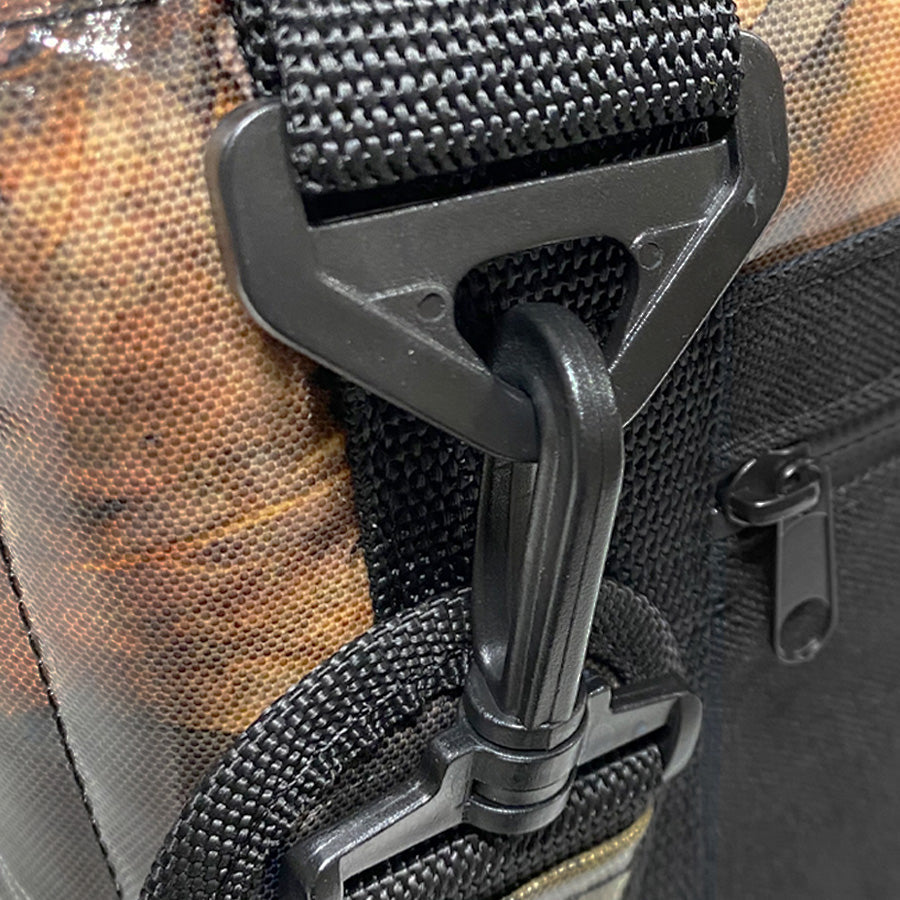 Close-up of a black buckle on a camouflage-patterned bag