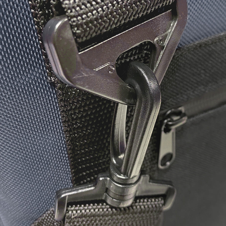 Close-up of a metal buckle on a bag strap with a blue background