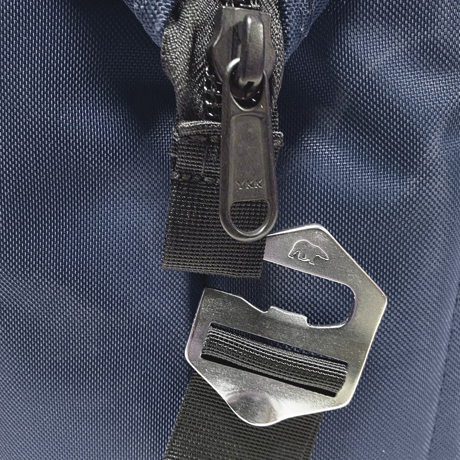 Close-up of a zipper and metal hook on a blue fabric background
