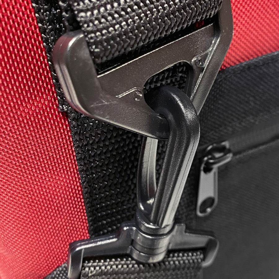 Close-up of a red bag with a black strap and metal buckle.