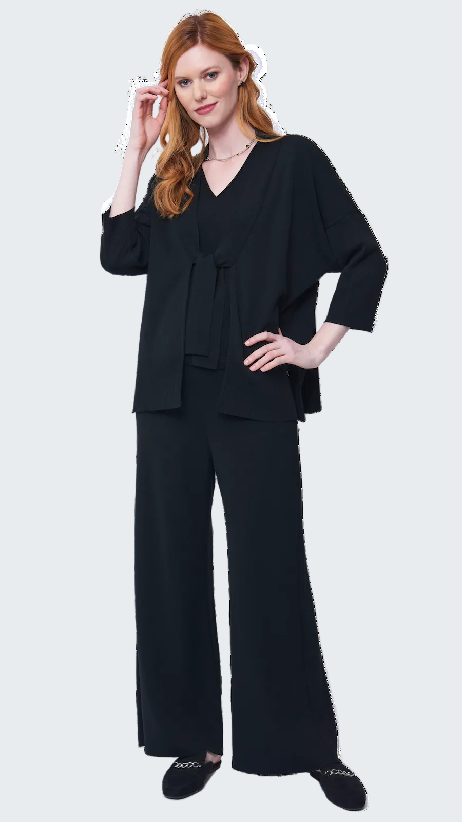 Woman wearing a black outfit with wide-leg pants on a white background