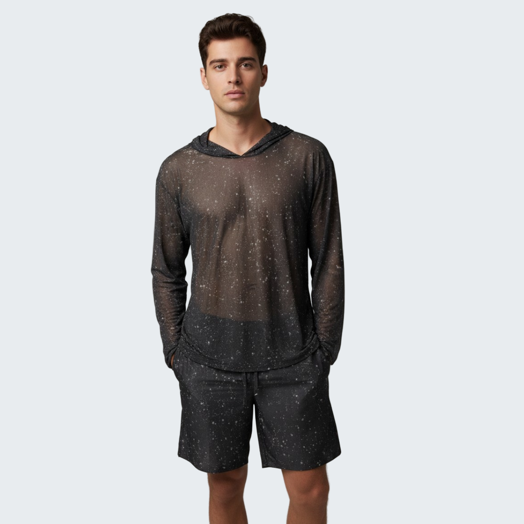 Man wearing a dark long-sleeve shirt and shorts with a subtle pattern on a gray background