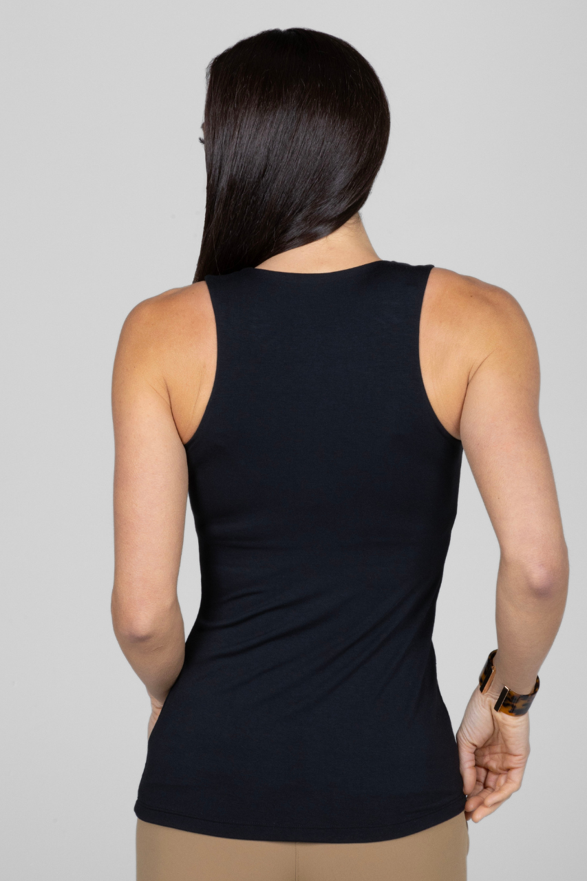 Person wearing a black sleeveless top on a plain background
