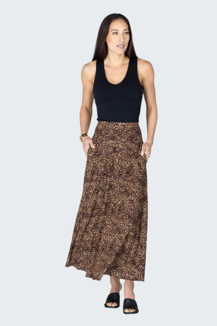 Woman wearing a black tank top and brown patterned skirt on a white background