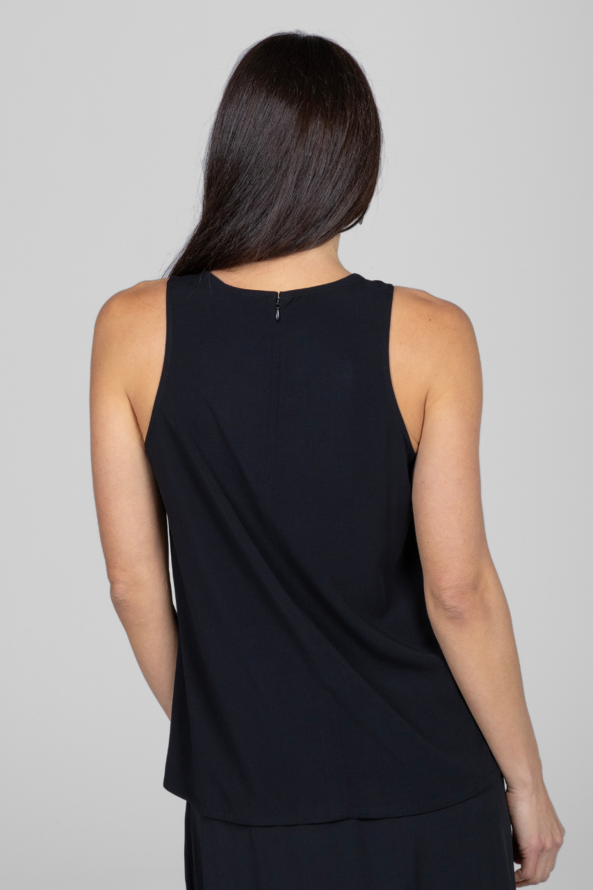 Person wearing a black sleeveless top against a gray background
