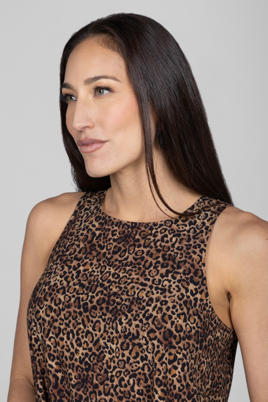 Woman wearing a leopard print top against a gray background