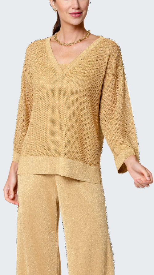 Woman wearing a gold knit outfit on a white background