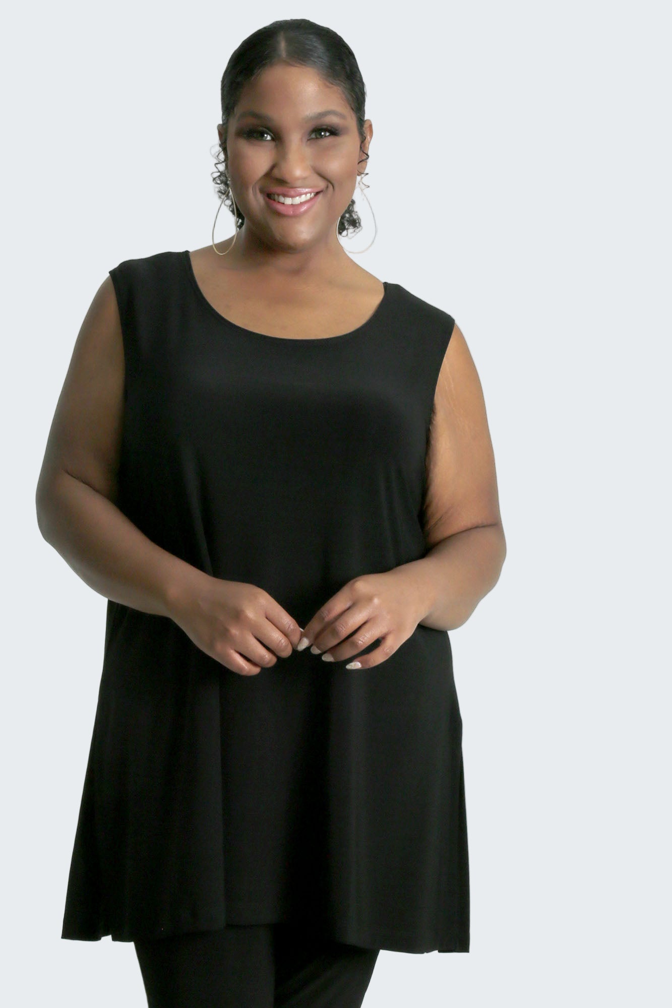 Woman wearing a black sleeveless top on a white background