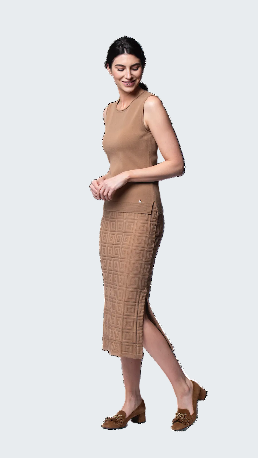Woman wearing a beige sleeveless dress with a slit on a white background