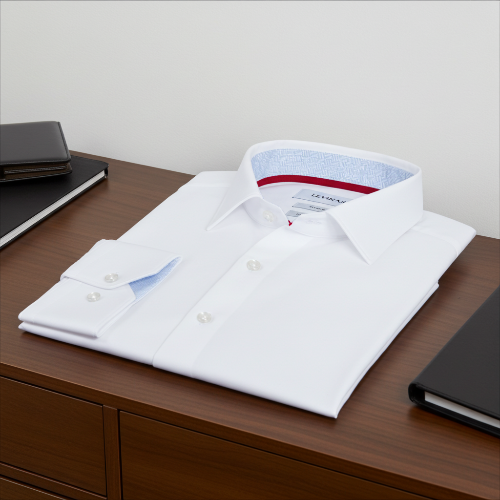Folded white dress shirt on a wooden surface with a neutral background