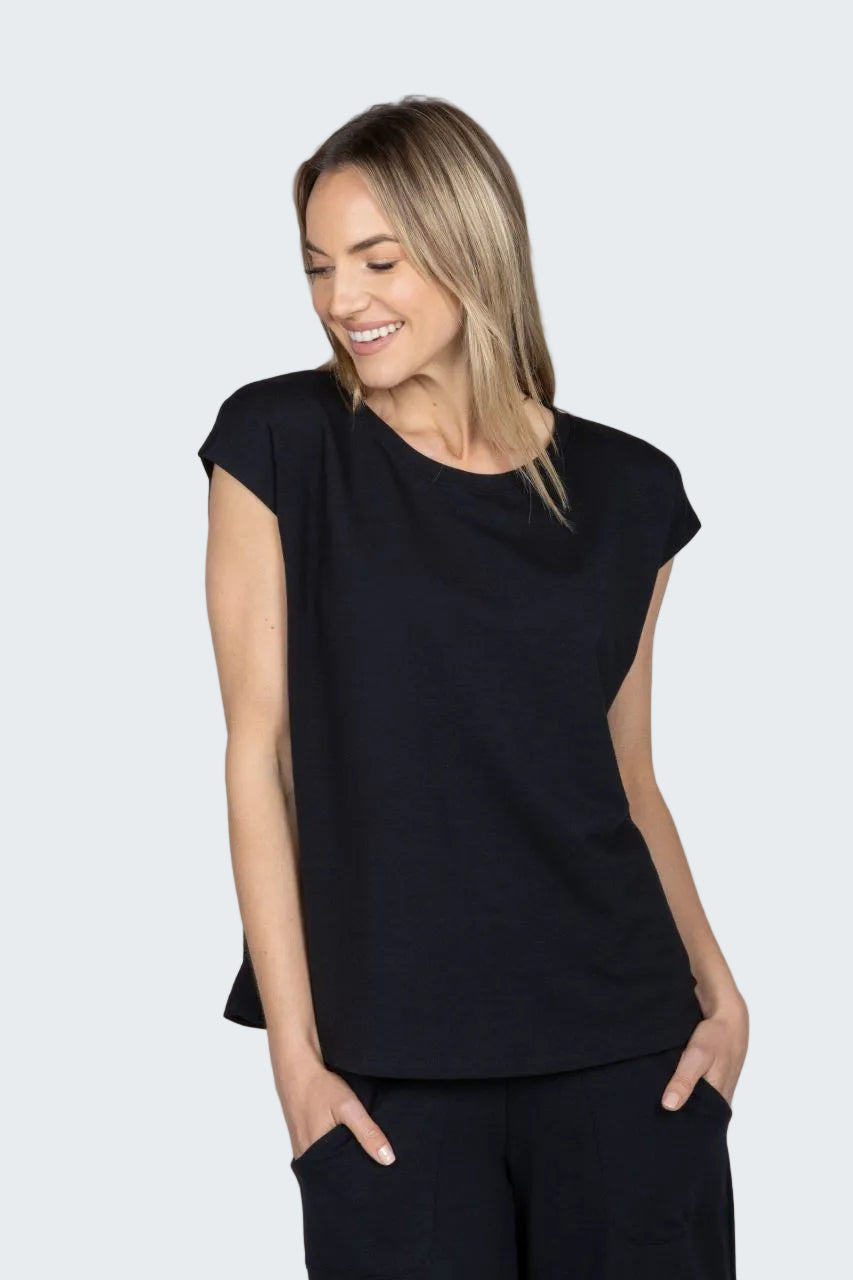 Woman wearing a black sleeveless top against a beige background