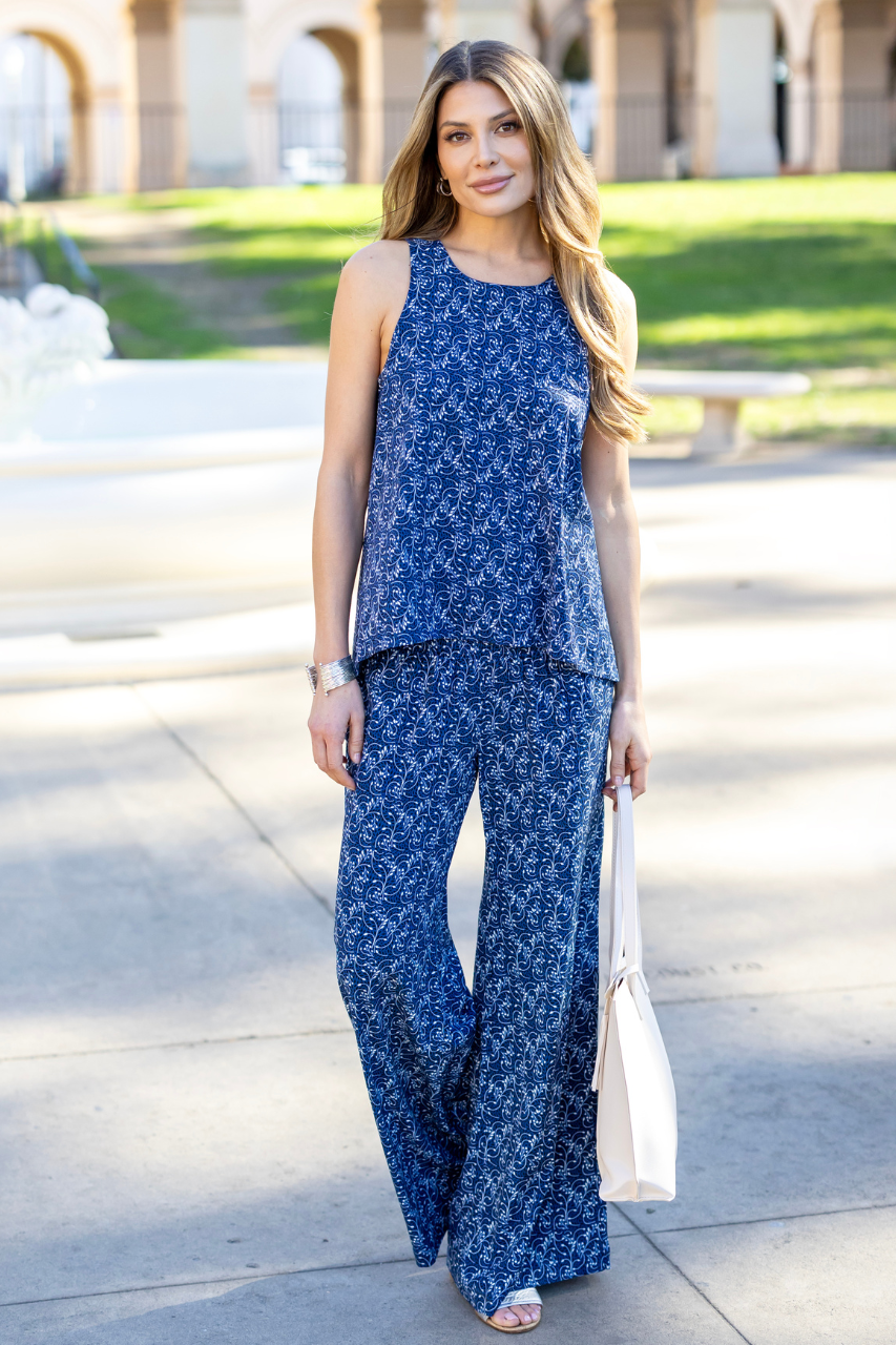 Woman wearing a blue floral outfit standing outdoors.