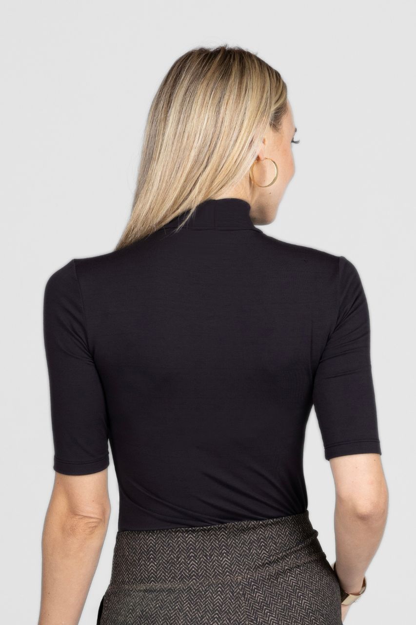 Person wearing a black turtleneck shirt on a plain background