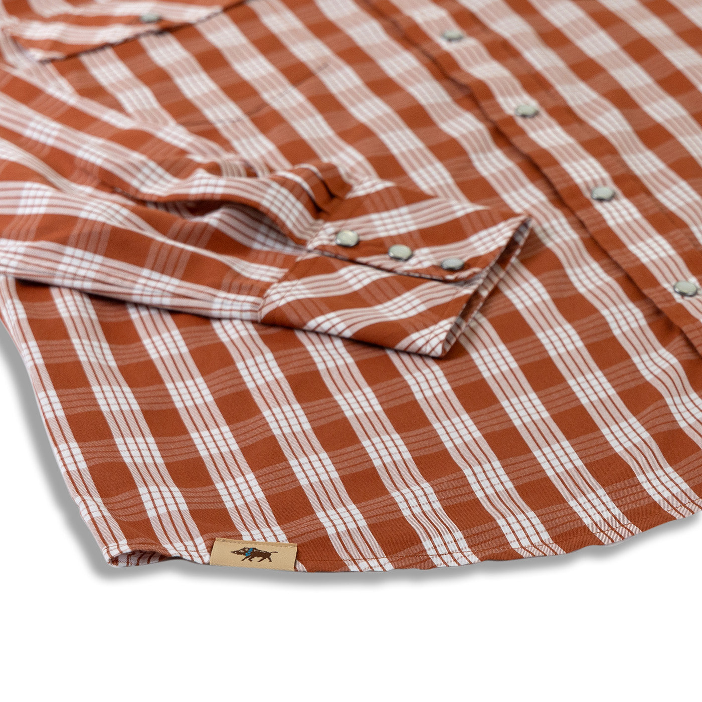 Close-up of a red and white checkered shirt with a brand label on a light gray background