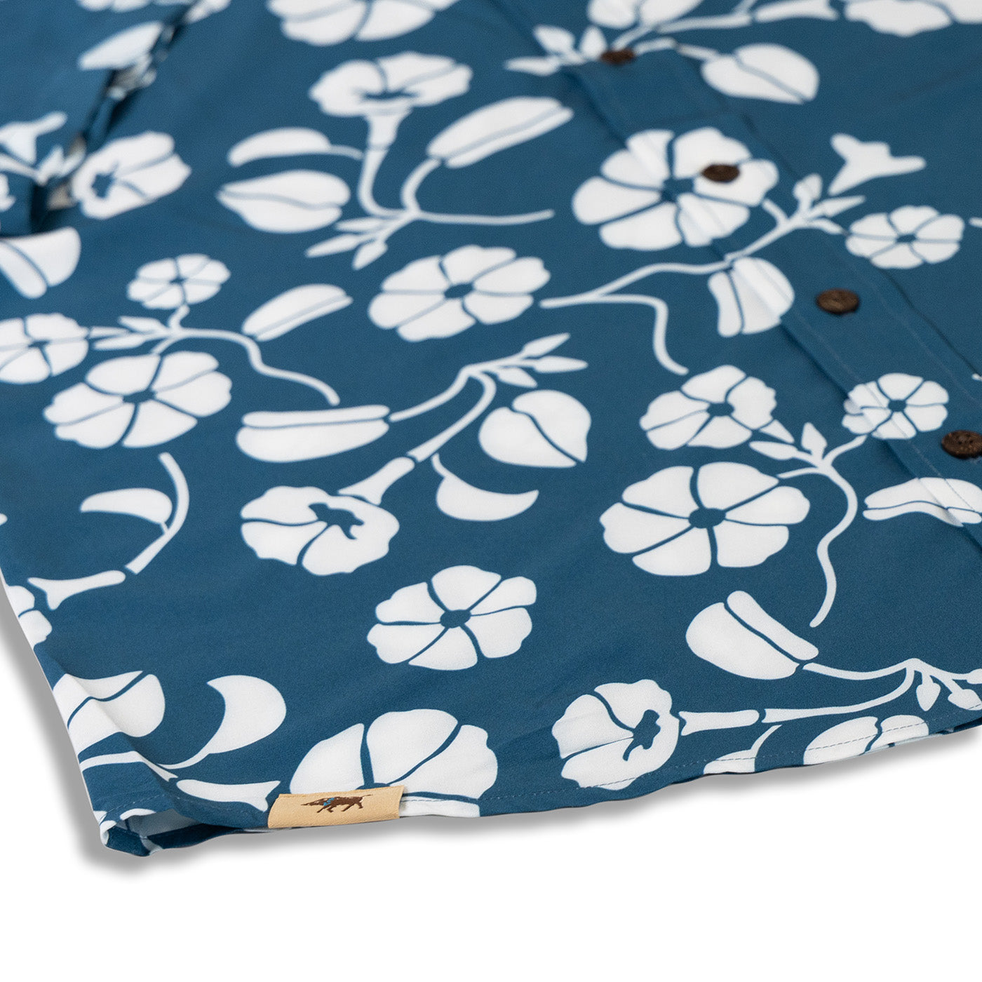 Blue fabric with white floral pattern and a brand label on a white background