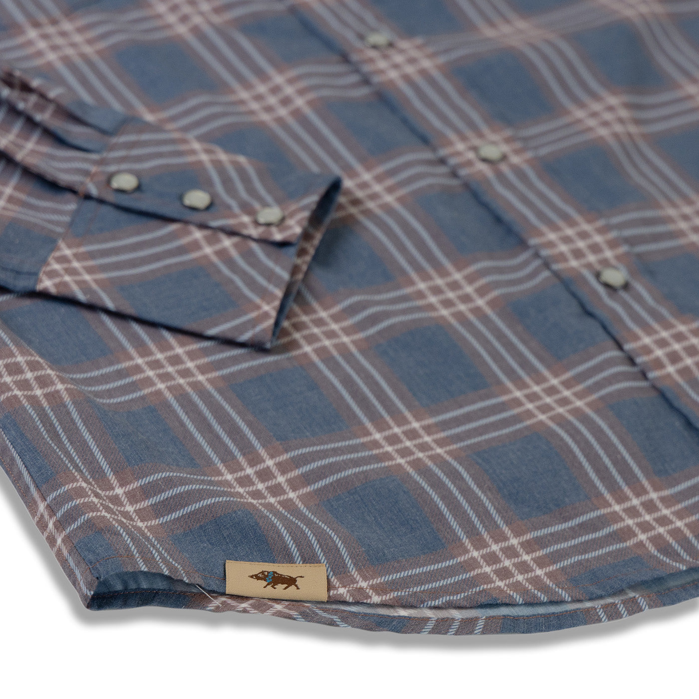 Close-up of a plaid shirt with a brand label on a white background