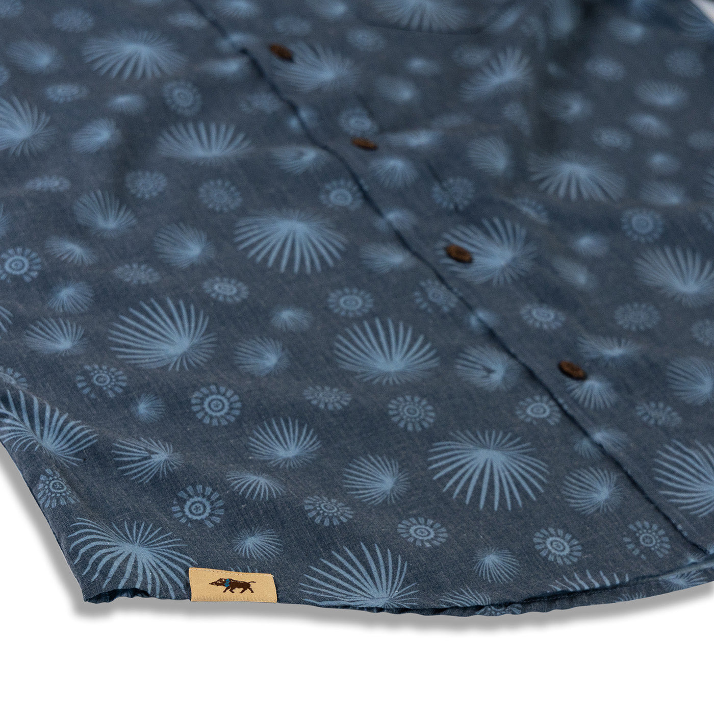 Blue fabric with white floral pattern and a brand label on a white background