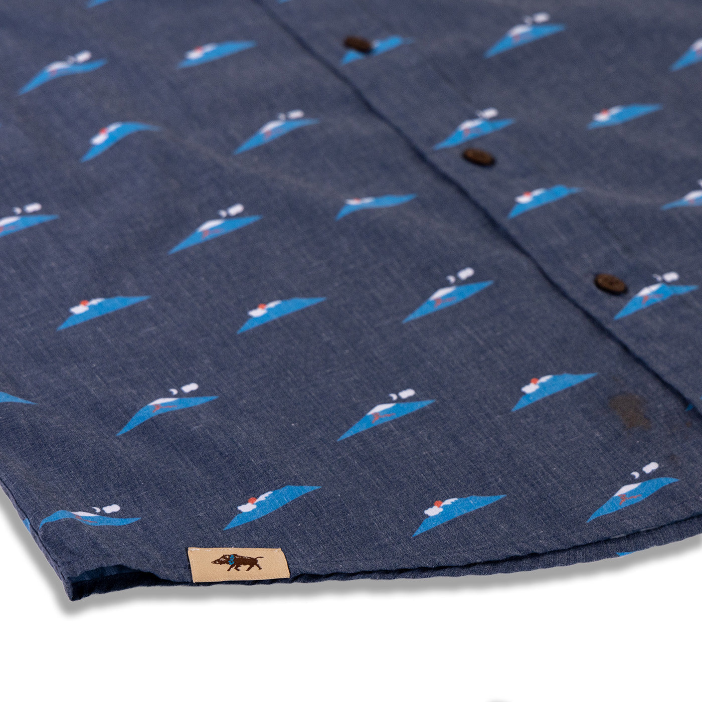 Navy shirt with whale pattern and brand label on a white background