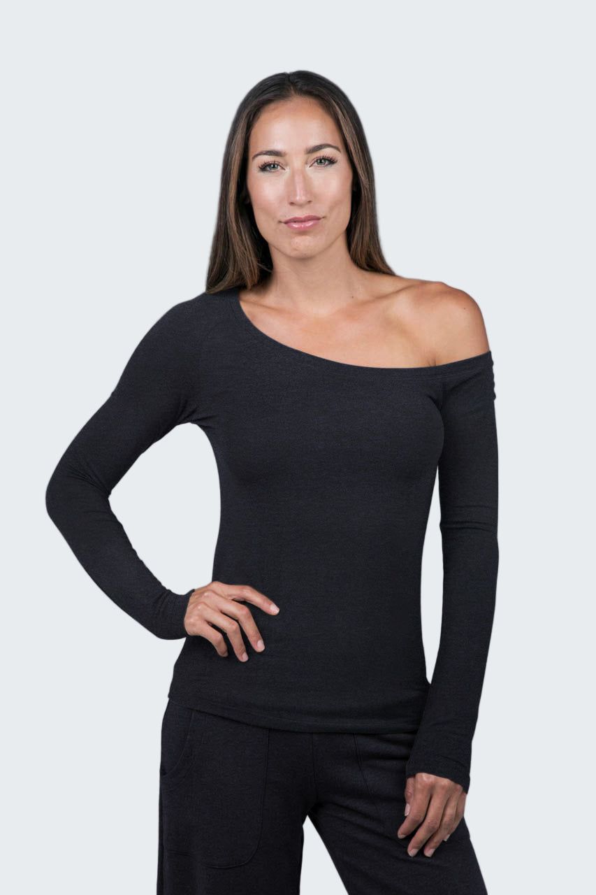 Woman wearing a black off-shoulder top against a gray background