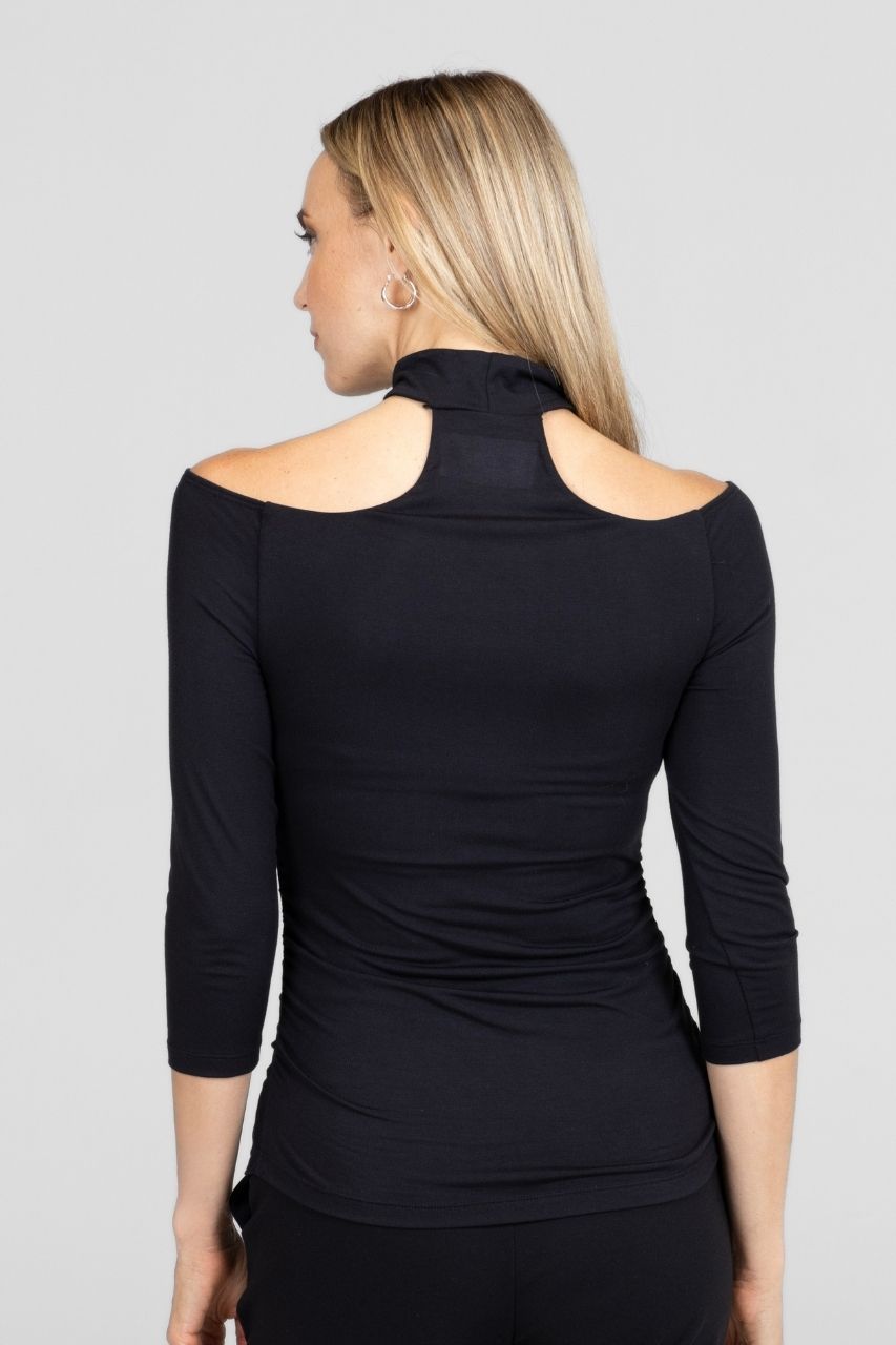 Woman wearing a black long-sleeve top with a cowl neck on a gray background