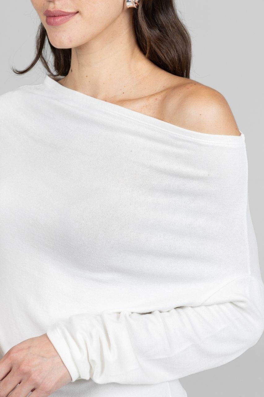 White off-shoulder top worn by a person on a plain background