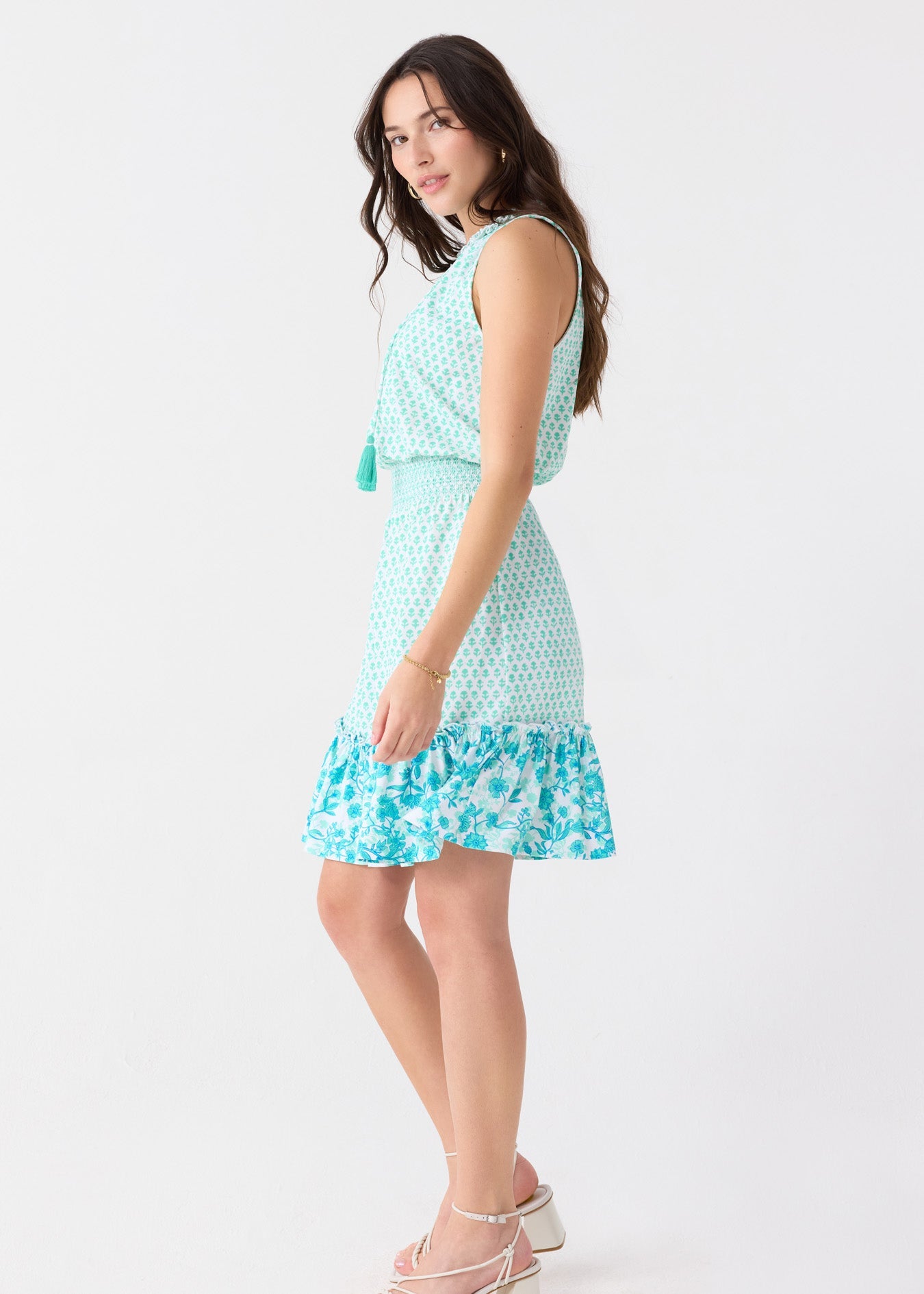Woman wearing a light blue dress with floral pattern on a white background