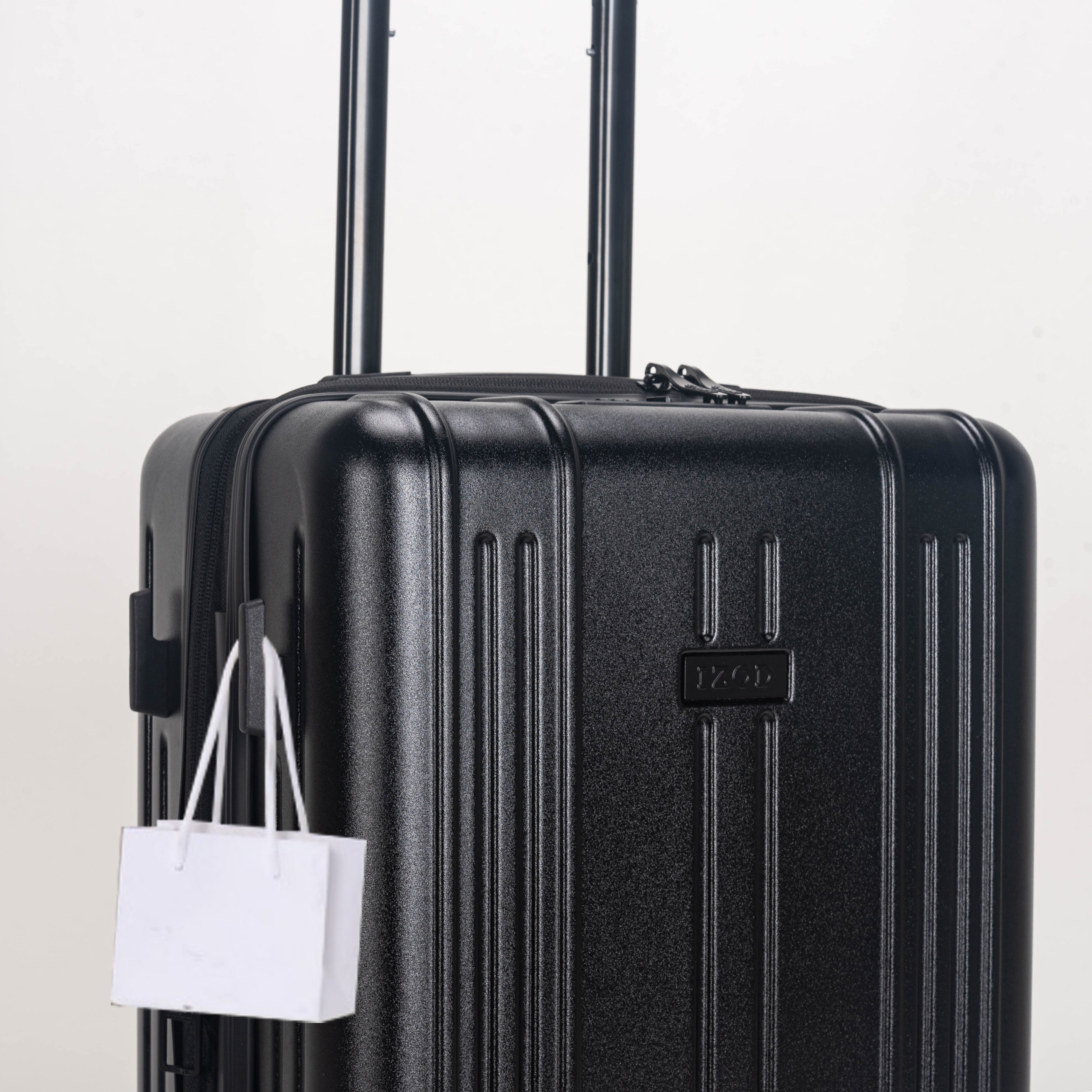 Black suitcase with a white shopping bag attached on a light gray background