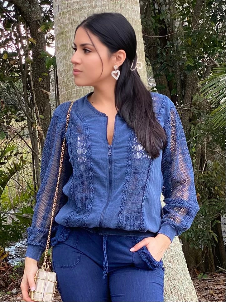 Woman wearing a blue outfit with a textured pattern, standing outdoors.