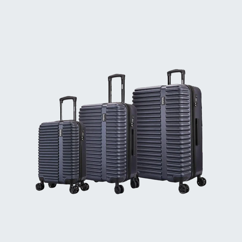 Set of three navy blue suitcases of different sizes on a white background