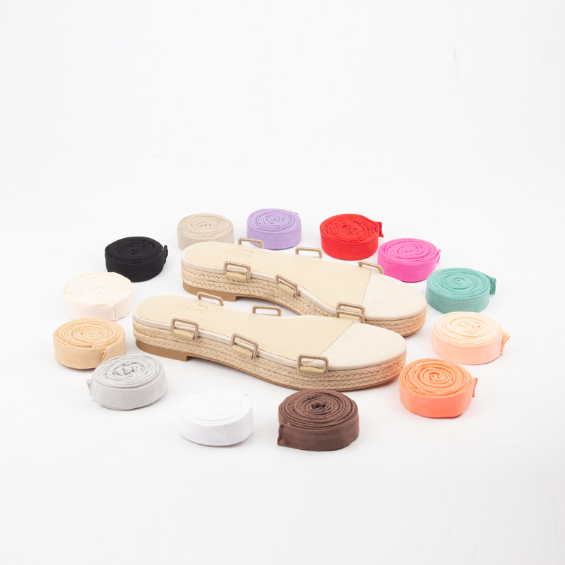 Colorful shoelaces displayed around a sandal on a white background