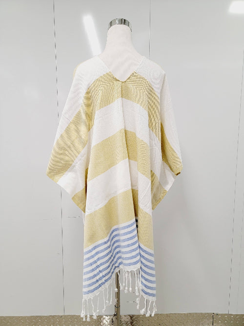 Mannequin wearing a yellow and white striped poncho with blue accents on a plain background