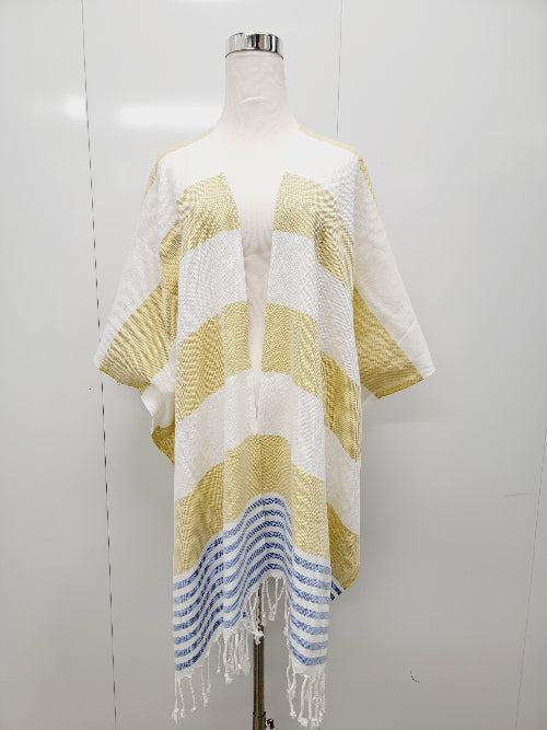 Mannequin wearing a striped yellow and white poncho with blue accents on a white background